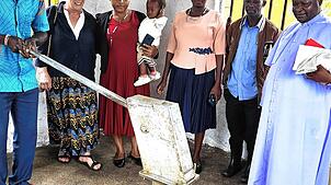 Father Peter (rechts) im neuen Brunnenhaus in Kasese. Foto: Claudia Jacobasch