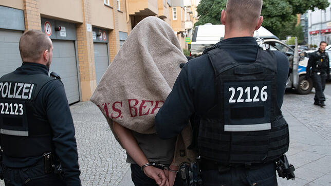 Berlin: Polizisten führen einen verdächtigen Mann nach einer Razzia gegen kriminelle Mitglieder arabischer Großfamilien ab. (Archiv)
