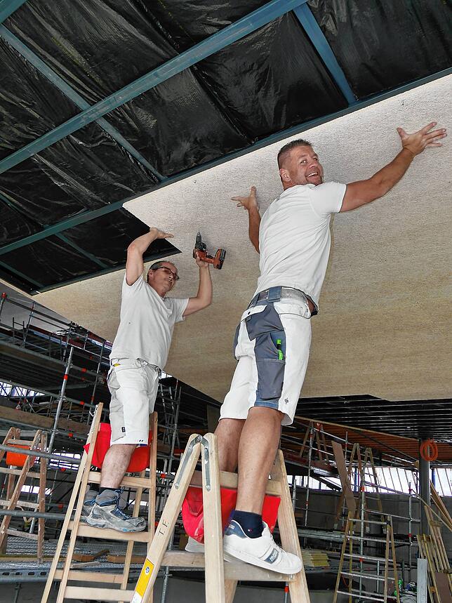 Zsolt Bicsák und Thomas Fröhlich (von links) montieren Holzwolle-Leichtbauplatten in der Decke des Schwaketenbads. Sie sorgen auch für ...