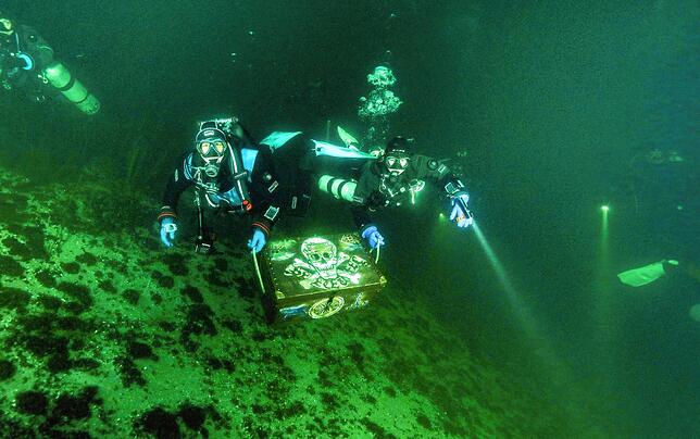 Maren Wagenbreth (links) und Fynn Gosse vom Tauchteam Bodensee transportieren die Schatzkiste zum Ufer.