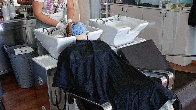 Franziska Taubenmann vom Salon Style Event in der Blumberger Tevesstraße bedient unter Einhaltung der aktuellen Hygienevorschriften eine ...