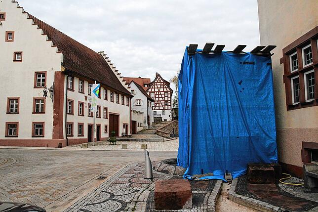 Der Narrenbrunnen ist mit einer blauen Plane gesichert, damit die Spritzarbeiten ungestört verlaufen können.