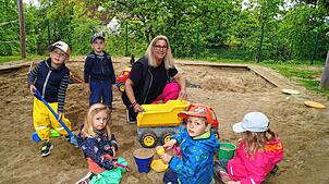 Kinderhausleiterin Birgit Hagg beschäftigt sich hier im Sandkasten mit Thilo, Leon, Mia, Raphael und Lia. Bild: Martina Wolters