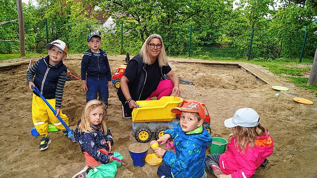 Kinderhausleiterin Birgit Hagg beschäftigt sich hier im Sandkasten mit Thilo, Leon, Mia, Raphael und Lia. Bild: Martina Wolters