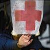 Ein Mann drückt ein Papier mit einem roten Kreuz gegen die Windschutzscheibe eines Busses, während Zivilisten aus Irpin evakuiert werden.