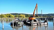 Mit einem Bagger wird Sediment aus dem Hafen in Bodman gehoben.