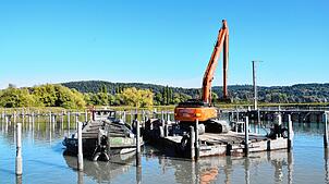 Mit einem Bagger wird Sediment aus dem Hafen in Bodman gehoben.