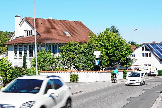 Dieser Radfahrer fährt gleich über den roten Streifen auf die Gegenfahrbahn.