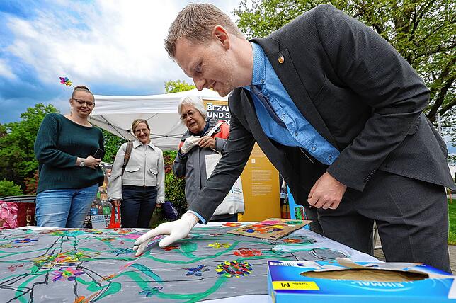 Künstler am Werk: OB Simon Gröger verwewigt sich auf dem Friedensbanner.