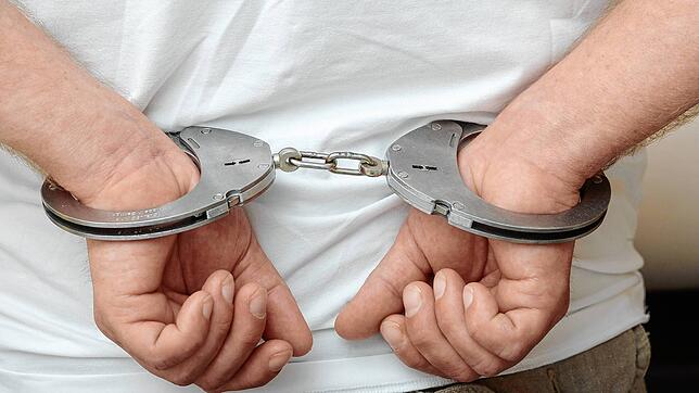 Ein Mann in Handschellen. (Symbolbild) Die Schaffhauser Polizei nimmt einen aggressiven Autofahrer fest, der dabei zwei Polizisten ...