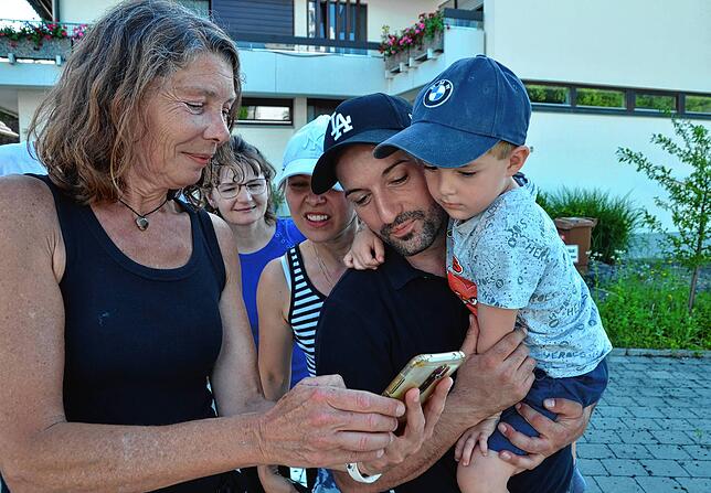 Ira Gemmeke (von links) zeigt  Rosina Mancino, Lydia Mancino, Angelo Mancino und Alessandro Mancino  die Bilder aus dem Nest.
