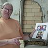 Gisela Rode steht vor der Mauer, hinter der sie Spuren eines Verbrechens vermutet, mit den Bildern ihres vermissten Neffen, Joachim ...