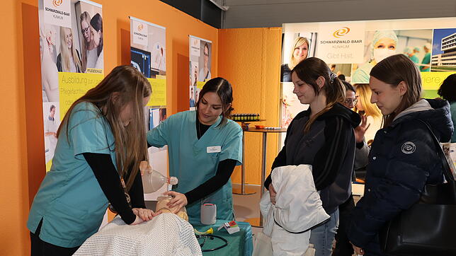 Jasmin Kaltenhauser und Vivien Milonovic, Auszubildende im Schwarzwald-Baar-Klinikum, zeigen auf der Jobs for Future Schülerinnen an ...