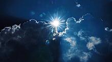 Die Sonne scheint am Rand von dunklen Wolken.
