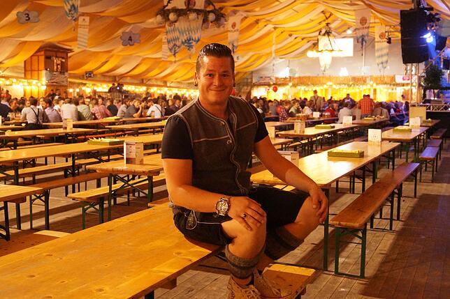 Entertainer Chris Metzger sitzt während des Konzertes der Geschwister Hofmann auf einem leeren Biertisch.