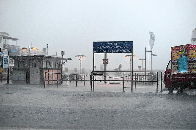 Mit viel Wind peitschte der Regen die Promenade entlang. Auch wer sich unterstellte, war vor dem Wasser nicht mehr sicher.