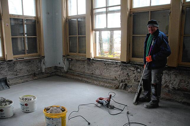 Jan Michalowicz kehrt den Bauschutt in einem der schönsten Räume aus – den Eckzimmern mit vielen Fenstern.