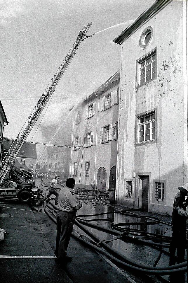 Während der Löscharbeiten wird das Revier schnell ausgeräumt und Polizisten sowie Feuerwehr rennen hin und her.