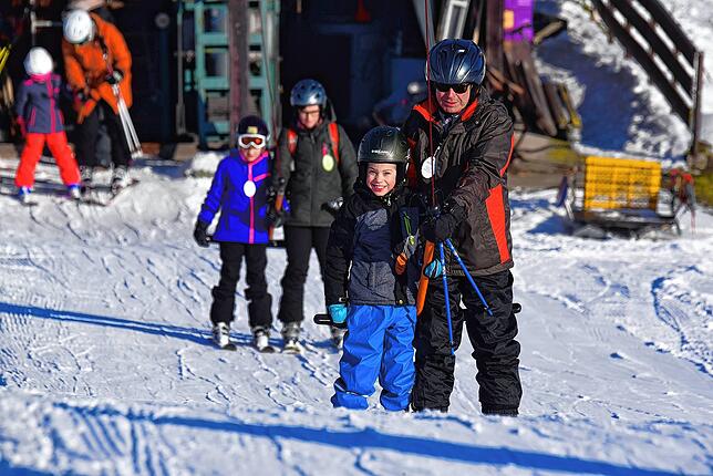 Skifahrer lassen sich im Januar 2019 von einem Schlepplift den Berg hochziehen.