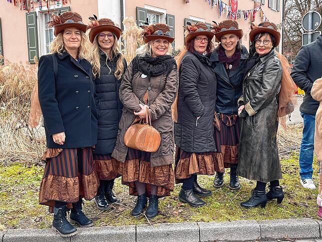 Feine Damen in nostalgischem Kostüm warten vor dem alten Rathaus auf den Narrenzug.