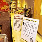 Schilder weisen im Eingangsbereich von Edeka Baur im E-Center in Konstanz auf virusbedingte Verhaltensregeln hin.