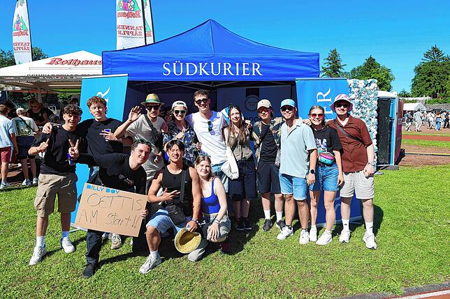 Gute gelaunte Festivalgänger vor dem SÜDKURIER-Stand beim Campus-Festival 2025. Auch die Pop-Up-Redaktion ist auf dem Gelände unterwegs ...