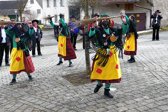 Die Schmotzige Dunschdig Hexen tanzen voller Freude um einen Baum
