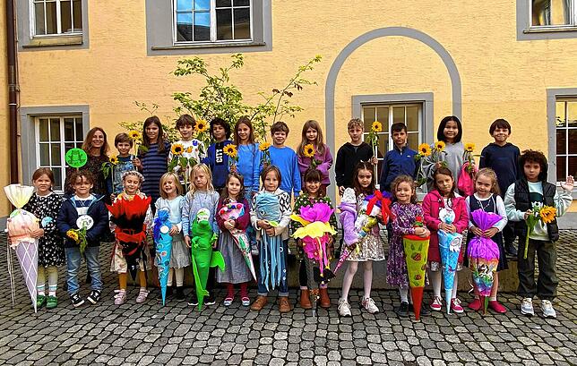 Die Schützlinge von Klassenlehrerin Daniela Walentin zeigen ihre Sonnenblumen, die sie an ihrem ersten Schultag zur Begrüßung geschenkt ...