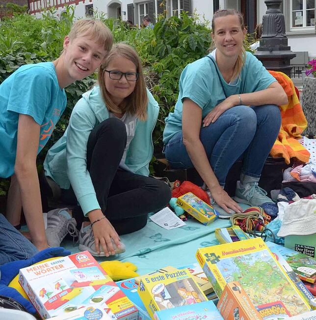 Paul, Lena und Alexa Löcken bieten Spiele und Spielsachen auf dem Kinderflohmarkt in der Kirchgasse an.