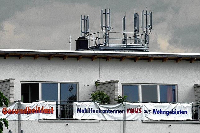 Anwohner protestieren in Kassel mit Transparenten mit der Aufschrift „Gesundheitslast“ und „Mobilfunkantennen raus aus ...