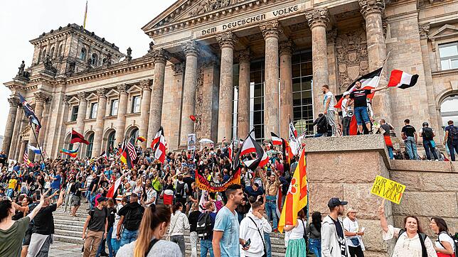 Teilnehmer einer Kundgebung gegen die Corona-Maßnahmen stehen am Samstag auf den Stufen zum Reichstagsgebäude, zahlreiche Reichsflaggen ...