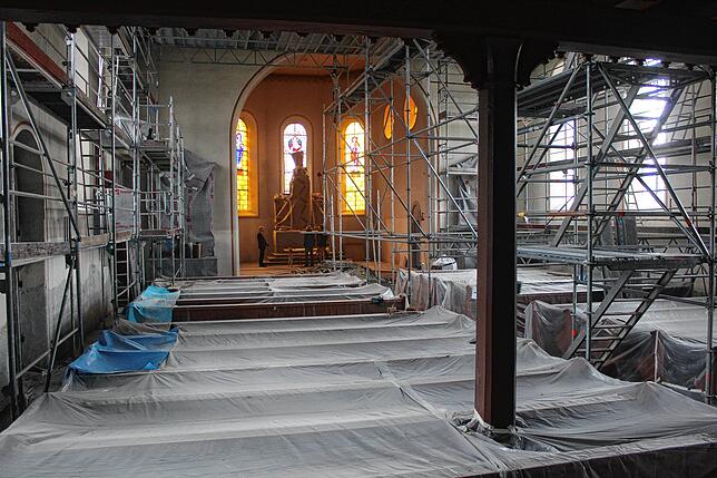 Der Innenbereich der Pfarrkirche St. Georg ist derzeit grau in grau. Einzig im Altarraum ist das Licht durch die bunten Kirchenfenster warm.