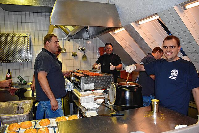 Feuerwehrleute wurden zu gut gelauntem Küchenpersonal, die Wurst, Pommes, Wecken und mehr zubereitet haben.
