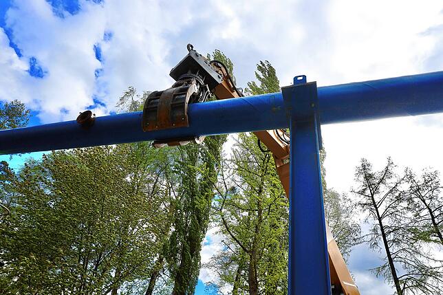 Die schweren Rohre werden mit dem Greifarm festgehalten.