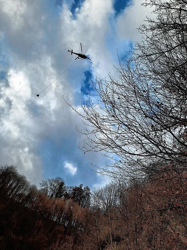 Ein Hubschrauber fliegt eine Maschine am Seil aus der Marienschlucht.