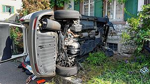 Ein Auto kracht in Riehen (Kanton Basel-Stadt) in eine Hauswand und kippt auf die Seite.