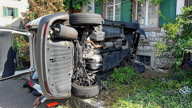 Ein Auto kracht in Riehen (Kanton Basel-Stadt) in eine Hauswand und kippt auf die Seite.