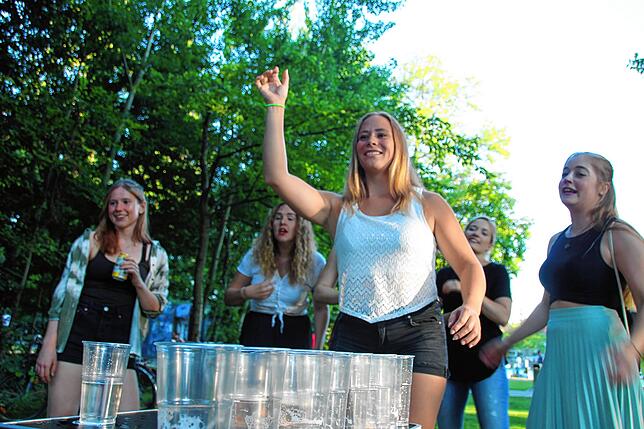 Eine Gruppe Studenten feiert Geburtstag einer Freundin mit Beerpong.