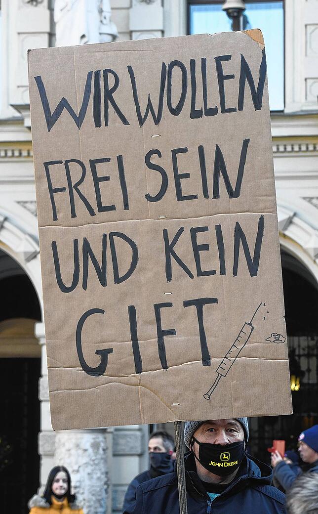Ein Demonstrant hält ein Schild mit der Aufschrift „Wir wollen frei sein und kein Gift“ bei einem Protest gegen ...