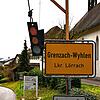 Ein Ampel-Schild und ein Gummischuh hängen an einem symbolischen Galgen am Ortseingangsschild. Bild: Heinz Vollmar