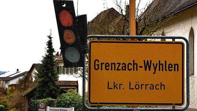 Ein Ampel-Schild und ein Gummischuh hängen an einem symbolischen Galgen am Ortseingangsschild. Bild: Heinz Vollmar