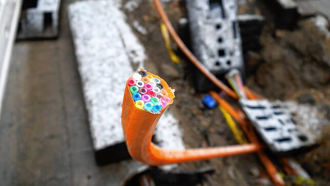 Kabel für Glasfaser ragen aus der Straße (Symbolbild). In Öhningen könnte der Breitbandausbau vielleicht der Gemeinde aus der Hand ...