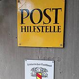 Zeitdokument an einer Wand auf der Terrasse: Der Grüne Baum war zu Beginn des 20. Jahrhunderts die lokale Post im Netz der Deutschen ...