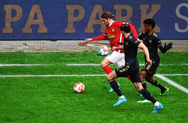 Freiburgs Lucas Höler (l) gegen Münchens Leon Goretzka (M) und Münchens Kingsley Coman (r).