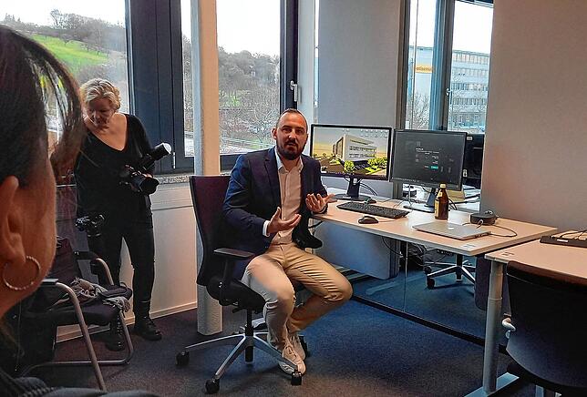 Technidata-Infrastrukturmanager Tobias Traue erläutert den Gästen der Einweihungsfeier das Konzept der individuell buchbaren Arbeitsplätze.