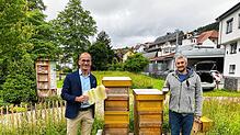 Bürgermeister Jörg Frey (links) und Imker Christian Brinkhus bei den Bienenvölkern im Schonacher Kurpark mit dem neu gewonnenen Honig. ...