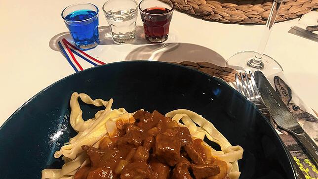 Waldshuter Gulasch und Flüssiges in den Stadtfarben Blau, Weiß und Rot stehen auf einem Esstisch.