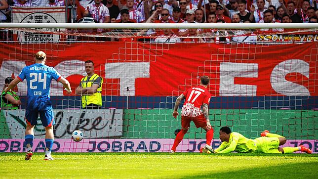 Freiburgs Torwart Noah Atubolu (r) verpasst einen Ball der Leipziger, der zum 0:1 führt während vor dem Tor Freiburgs Lukas Kübler (m) ...