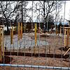 Ein Spielplatz hinter Gittern. Aber nur solange, bis der noch nicht gewachsene Rasen zwischen den Spielgeräten Grün signalisiert.