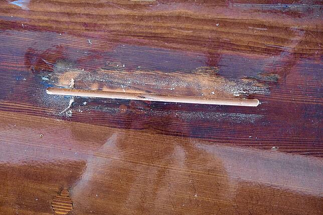 Risse im Holz werden ausgesägt und nachher durch genau eingepasste Holzteile verschlossen.